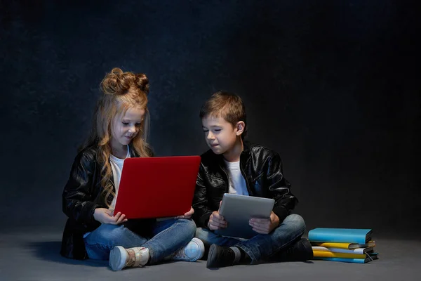 Estúdio tiro de duas crianças com computador portátil — Fotografia de Stock