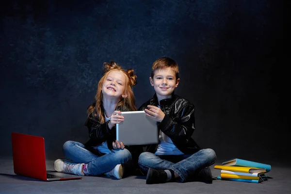 Estúdio tiro de duas crianças com computador portátil — Fotografia de Stock