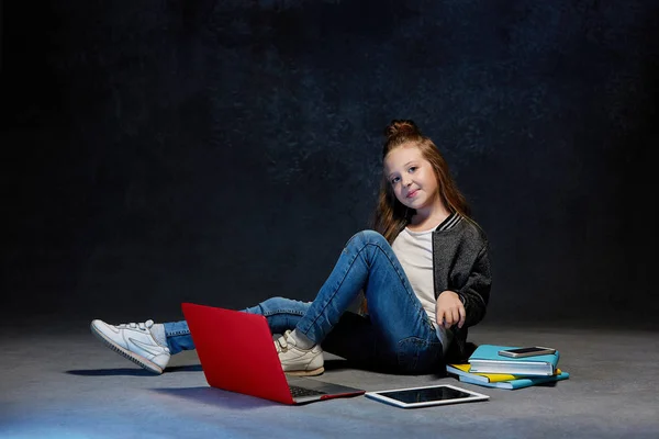 Μικρό κορίτσι που κάθεται με gadgets — Φωτογραφία Αρχείου