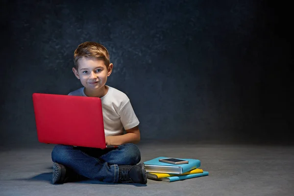 Маленький хлопчик сидить з ноутбуком в студії — стокове фото
