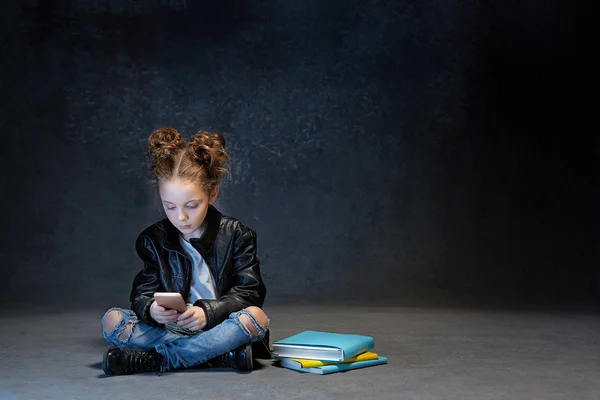 Μικρό κορίτσι που κάθεται με το smartphone στο studio — Φωτογραφία Αρχείου