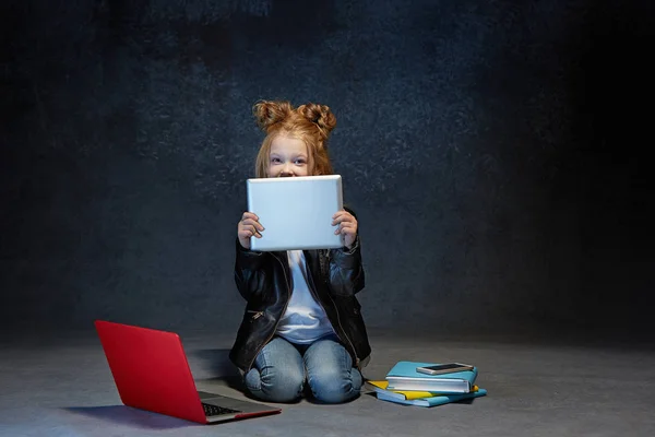 Kleines Mädchen sitzt mit Gadgets — Stockfoto