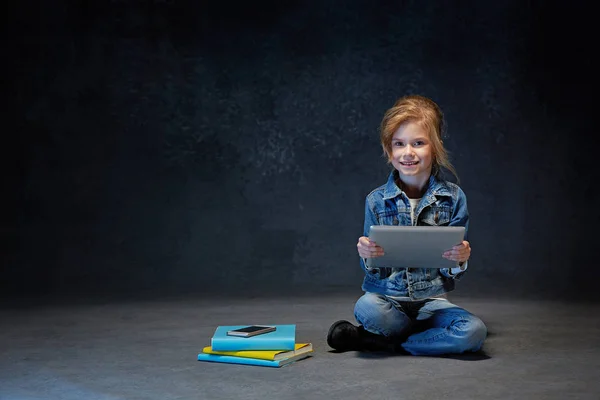 Маленька дівчинка сидить з планшетом — стокове фото