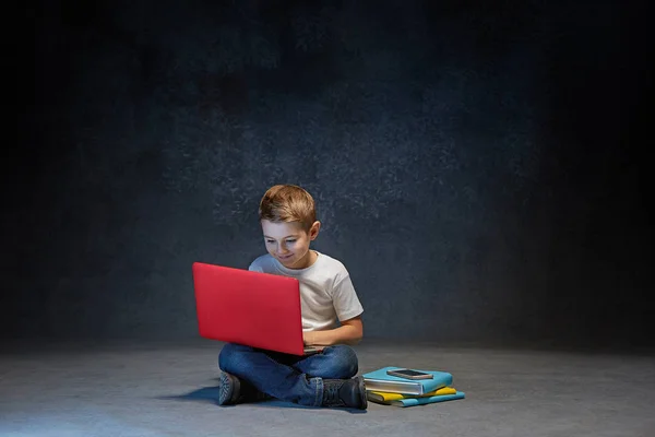 Niño sentado con portátil en el estudio — Foto de Stock