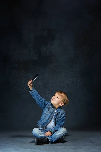 Niño sentado con smartphone en el estudio — Foto de Stock