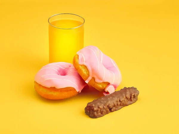 Çörek ve Sarı zemin üzerine taze portakal suyu — Stok fotoğraf