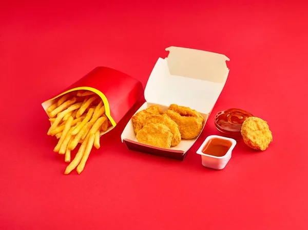 Nuggets de frango e batatas fritas no fundo vermelho — Fotografia de Stock