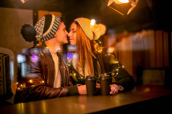 Pareja joven besándose y abrazándose al aire libre en la calle de la noche en Navidad — Foto de Stock