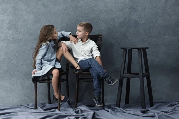 Портрет маленькой девочки и мальчика на сером фоне — стоковое фото