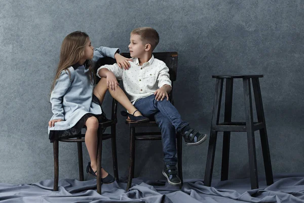 Портрет маленькой девочки и мальчика на сером фоне — стоковое фото