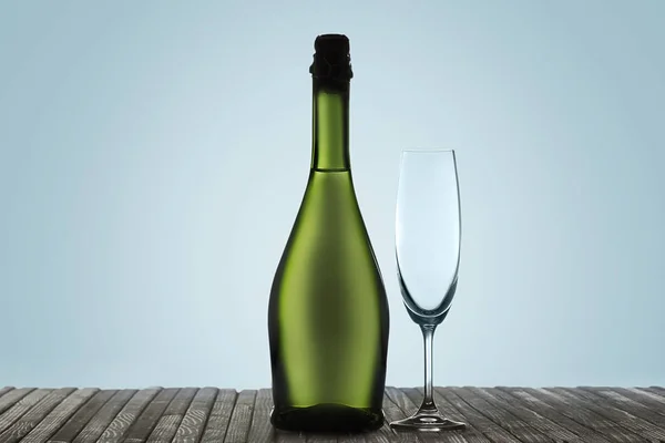 Glazen met champagne en fles over mousserende vakantie achtergrond — Stockfoto