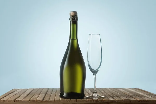 Glazen met champagne en fles over mousserende vakantie achtergrond — Stockfoto