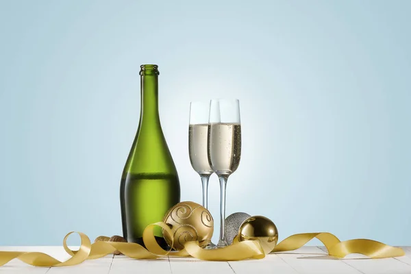 Copas con champán y botella sobre fondo brillante de vacaciones —  Fotos de Stock