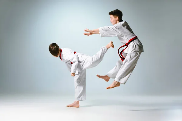 Estúdio de duas crianças treinando karatê artes marciais — Fotografia de Stock