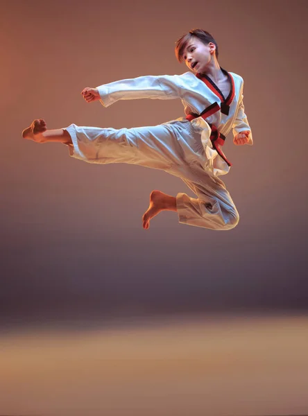 Fiatal fiú képzés karate-kék háttér — Stock Fotó