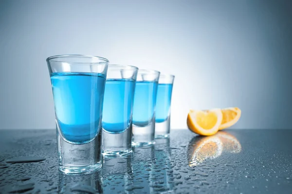 Стакан водки со льдом на синем фоне — стоковое фото