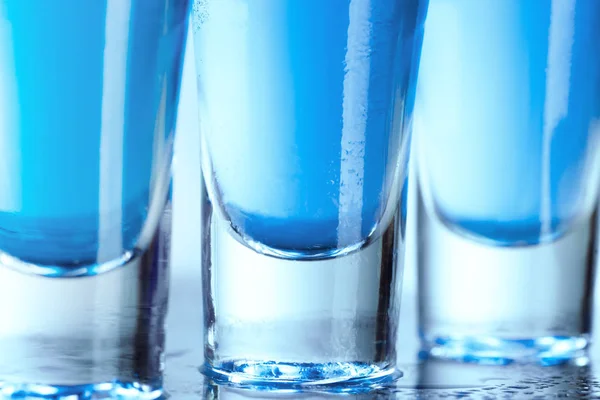 Vodka glass with ice on blue background — Stock Photo, Image