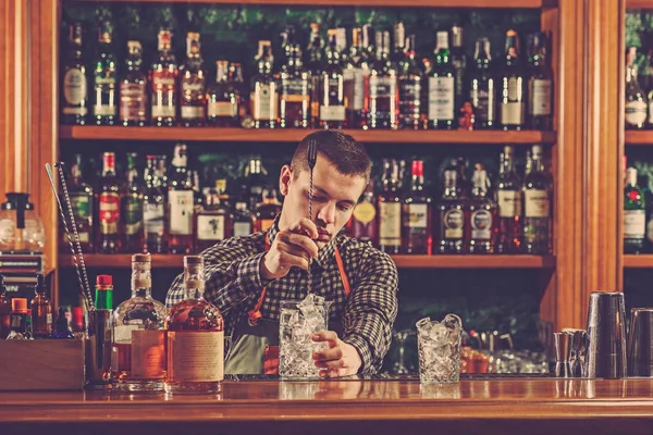 Barman making an alcoholic cocktail at the bar counter on the bar background — Stock Photo, Image