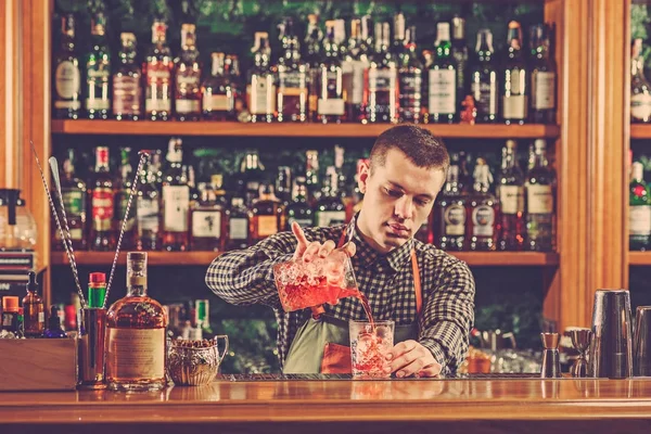 Barman making an alcoholic cocktail at the bar counter on the bar background — Stock Photo, Image