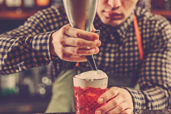 Barman making an alcoholic cocktail at the bar counter on the bar background — Stock Photo, Image