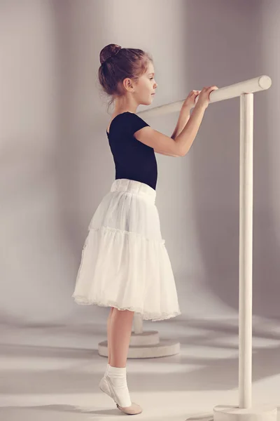 Маленька танцівниця балерина на сірому фоні — стокове фото