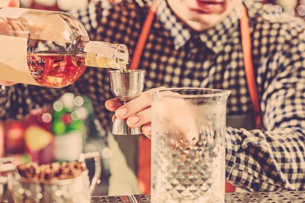 Barman haciendo un cóctel alcohólico en el mostrador del bar en el fondo del bar — Foto de Stock