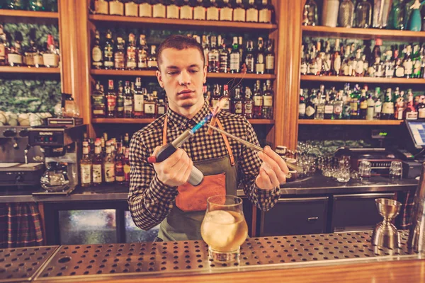 Barman haciendo un cóctel alcohólico en el mostrador del bar en el fondo del bar — Foto de Stock