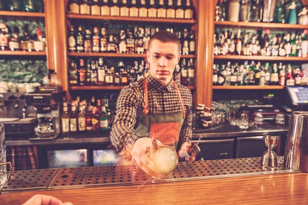 Bartender membuat koktail alkohol di bar counter pada latar belakang bar — Stok Foto