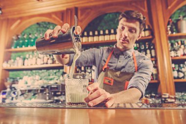 Uzman barmen gece kulübünde kokteyl hazırlıyor..