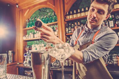 Uzman barmen gece kulübünde kokteyl hazırlıyor..