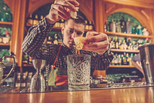 Barman haciendo un cóctel alcohólico en el mostrador del bar en el fondo del bar —  Fotos de Stock