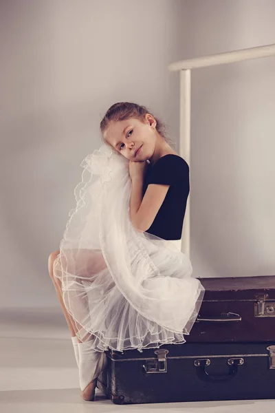 Маленькая девочка в роли балерины танцовщицы, сидящей в студии — стоковое фото