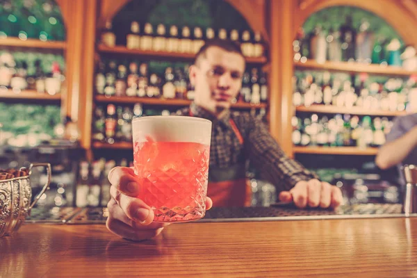 Barman nabízí alkoholické koktejly v baru čítačů na panelu pozadí — Stock fotografie
