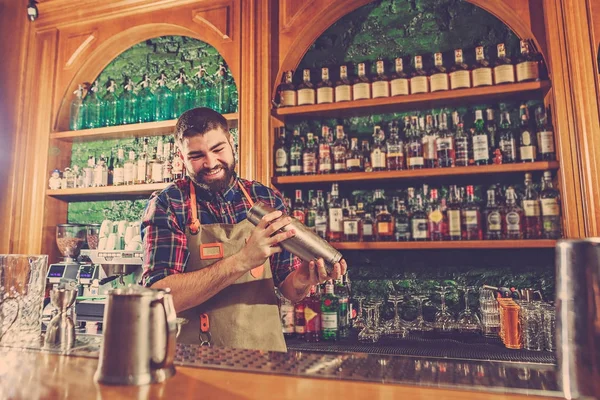 Barman haciendo un cóctel alcohólico en el mostrador del bar en el fondo del bar — Foto de Stock
