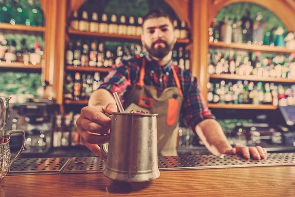 Barman haciendo un cóctel alcohólico en el mostrador del bar en el fondo del bar — Foto de Stock