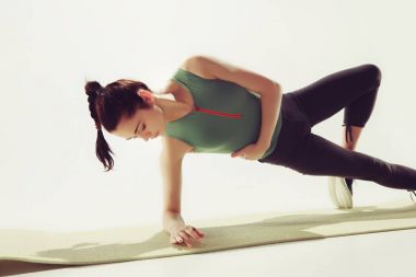 Güzel ince esmer, spor salonunda esneme egzersizleri yapıyor.