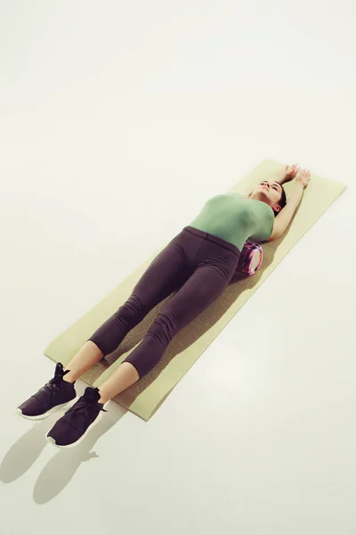 Vista frontale di una giovane donna che allunga il corpo in classe di ginnastica . — Foto Stock