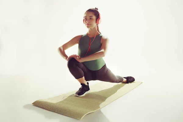 Vista frontal de una joven mujer estirando el cuerpo en clase de gimnasia . —  Fotos de Stock