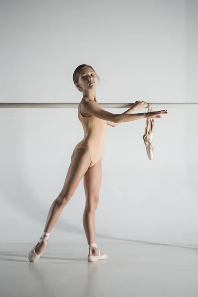 A menina está treinando perto do ballet barre . — Fotografia de Stock