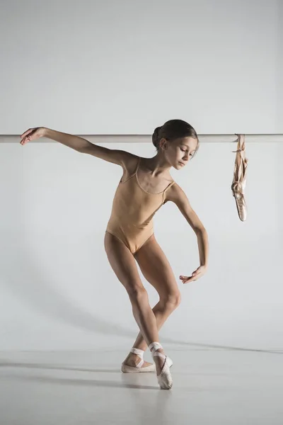 The girl is training near the ballet barre. — Stock Photo, Image