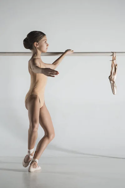 La fille s'entraîne près de la barre de ballet . — Photo