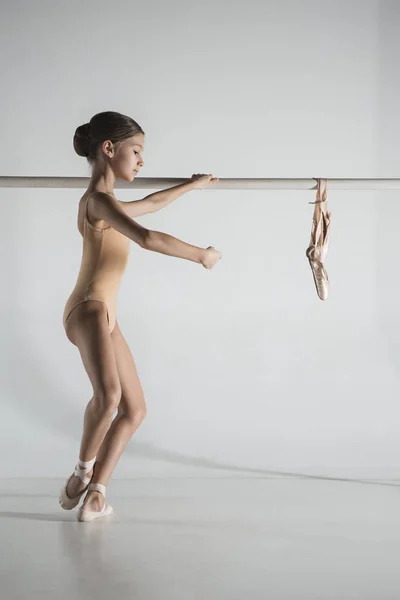 A menina está treinando perto do ballet barre . — Fotografia de Stock