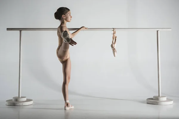 A menina está treinando perto do ballet barre . — Fotografia de Stock