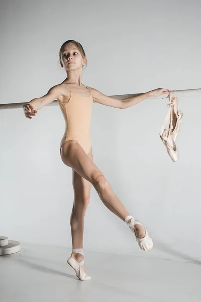 La chica está entrenando cerca de la barra de ballet . —  Fotos de Stock