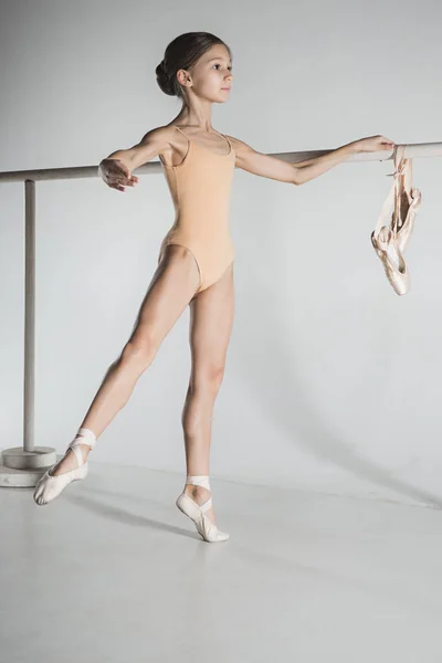 A menina está treinando perto do ballet barre . — Fotografia de Stock