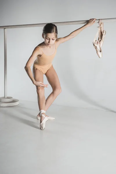 La chica está entrenando cerca de la barra de ballet . — Foto de Stock