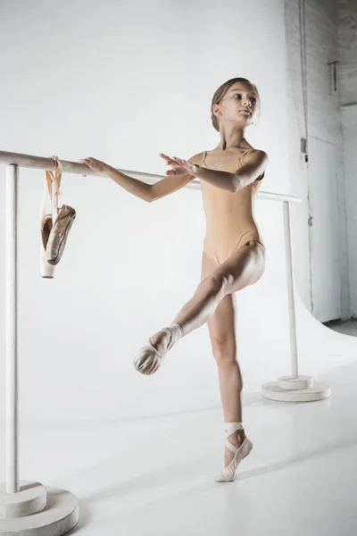 La chica está entrenando cerca de la barra de ballet . —  Fotos de Stock