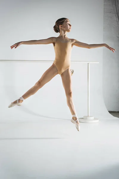 La chica está entrenando cerca de la barra de ballet . — Foto de Stock