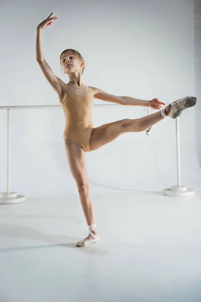 La chica está entrenando cerca de la barra de ballet . —  Fotos de Stock