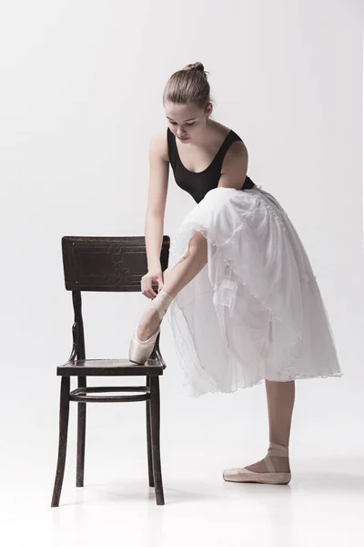 La ballerine adolescente en paquet blanc posant près de la chaise — Photo